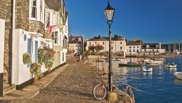 A cobblestone waterfront with buildings, a bicycle, and boats. - 42 Dart Marina (Dartmouth)