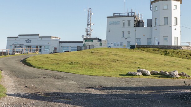 A building with multiple white structures, including a prominent tower with antennas.