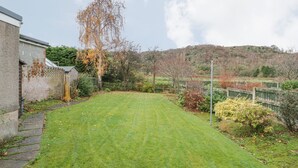 A well-maintained grassy yard with a brick wall and a wooden fence.