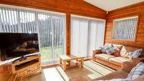 Una sala de estar con muebles de madera, una televisión, un sofá y una mesa de centro.