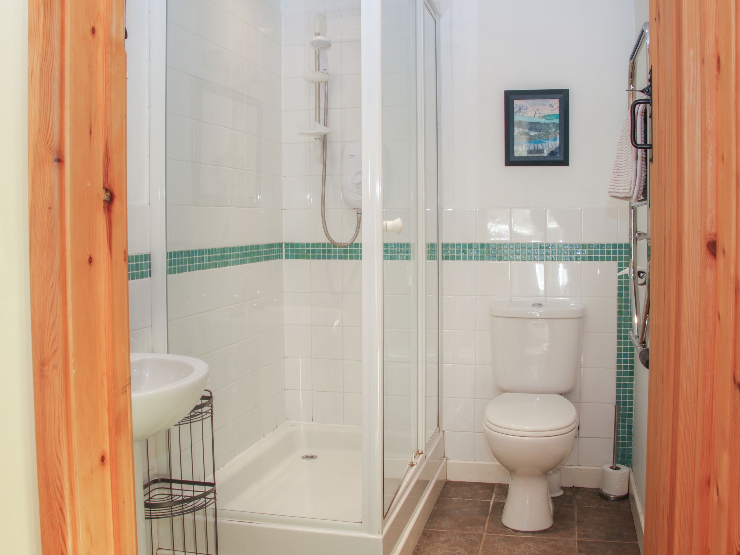 Une salle de bain avec douche, toilettes et lavabo.