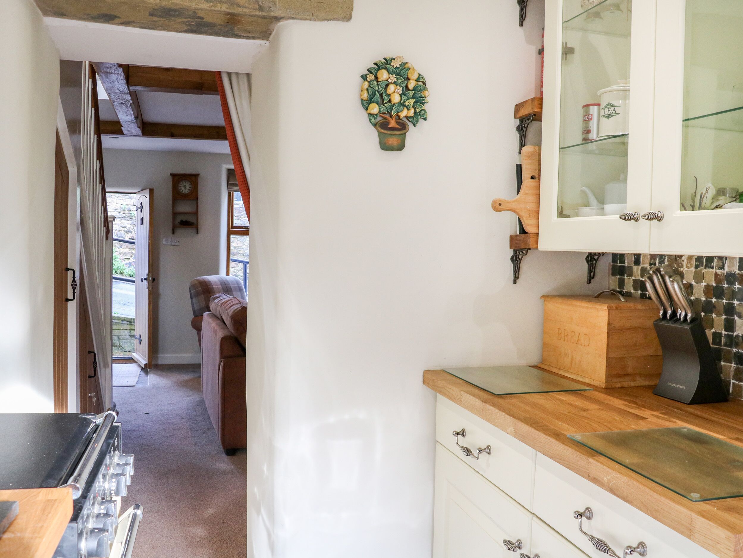 A kitchen with wooden cabinets, a glass-top countertop, and a decorative plant.
