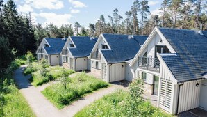 Hytter med skrå tage og en sti, der går gennem en græsplæne.