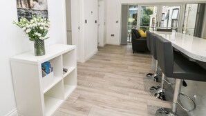 Eine moderne Küche mit weißer Arbeitsplatte, einem eingebauten Ofen und einer Spüle aus Edelstahl.