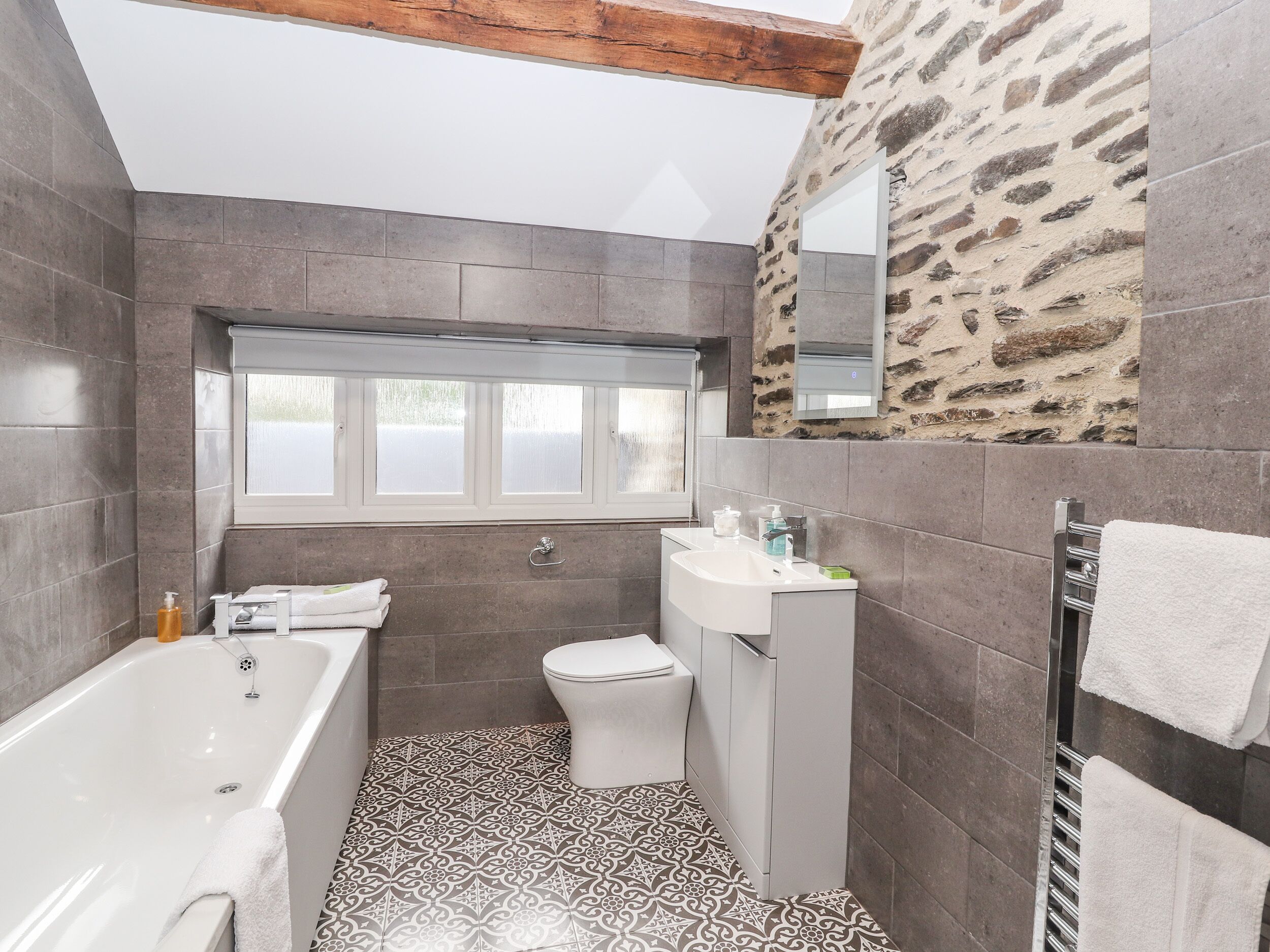 A modern bathroom with a bathtub, toilet, and sink.
