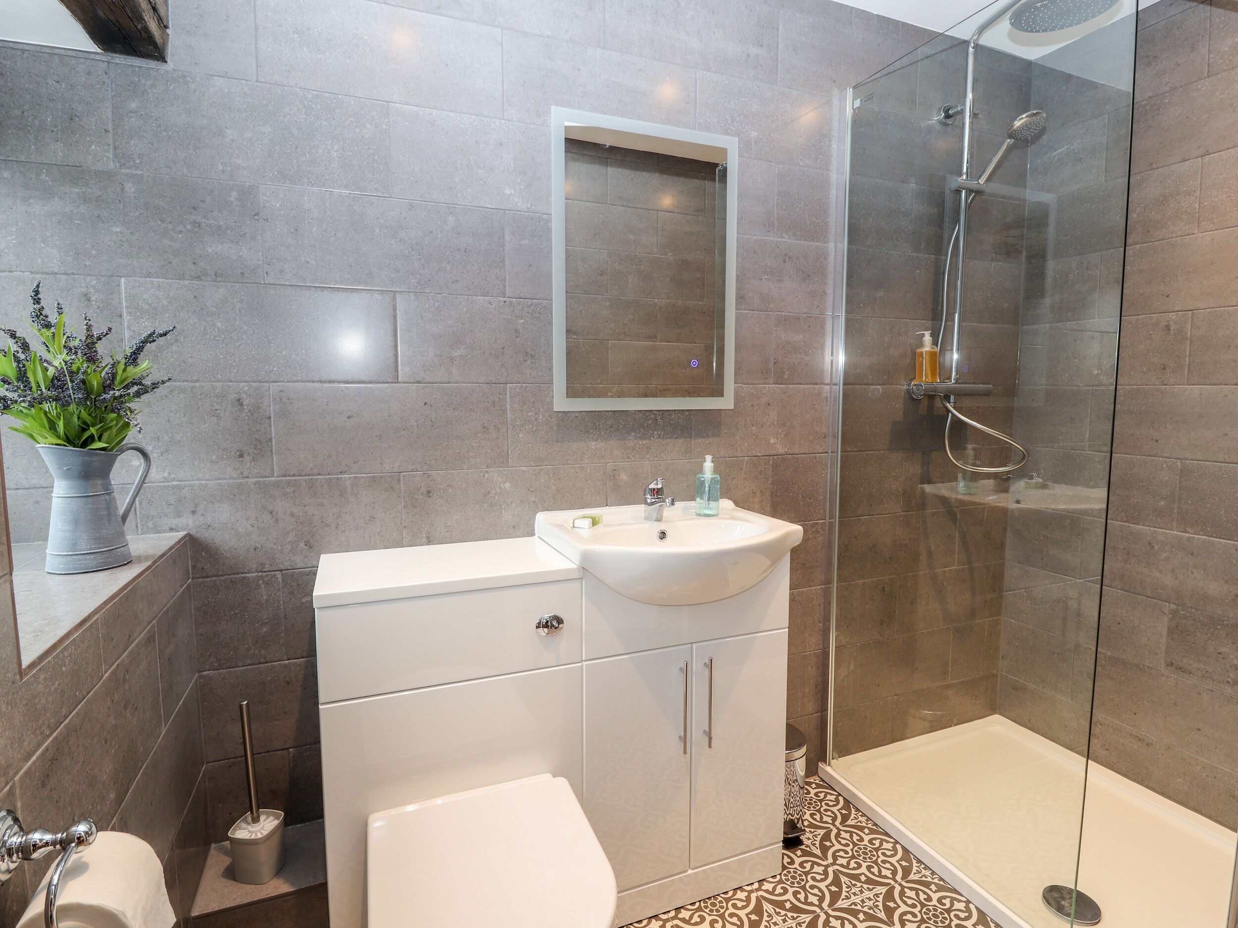 Un baño moderno con inodoro, lavamanos y ducha.