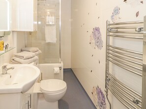 A bathroom with a glass shower enclosure, a sink, a toilet, and a towel rack. - Llys Madoc, First Floor Flat (Abergele)