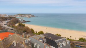 Une ville côtière avec une plage, des bâtiments et un ciel dégagé.