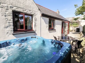 Ein Whirlpool vor einem Haus mit zwei Fenstern und einer Tür.