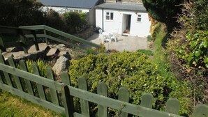 A residential property with a stone staircase leading to a white house with a dark roof. - Derlwyn (Newport)