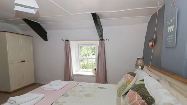 A bedroom with a bed, a window, a wardrobe, and a bedside lamp. - Panteg, Cardigan (Cardigan)