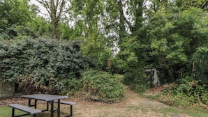 A picnic table in a grassy area with dense foliage and trees in the background. - Panteg, Cardigan (Cardigan)