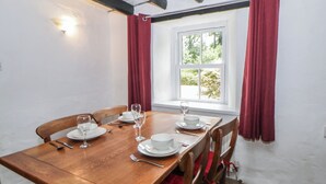 A dining area with a wooden table set for four, white plates, and wine glasses. - Panteg, Cardigan (Cardigan)
