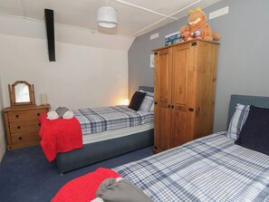 A bedroom with two beds, a wardrobe, a mirror, and a lamp. - Panteg, Cardigan (Cardigan)