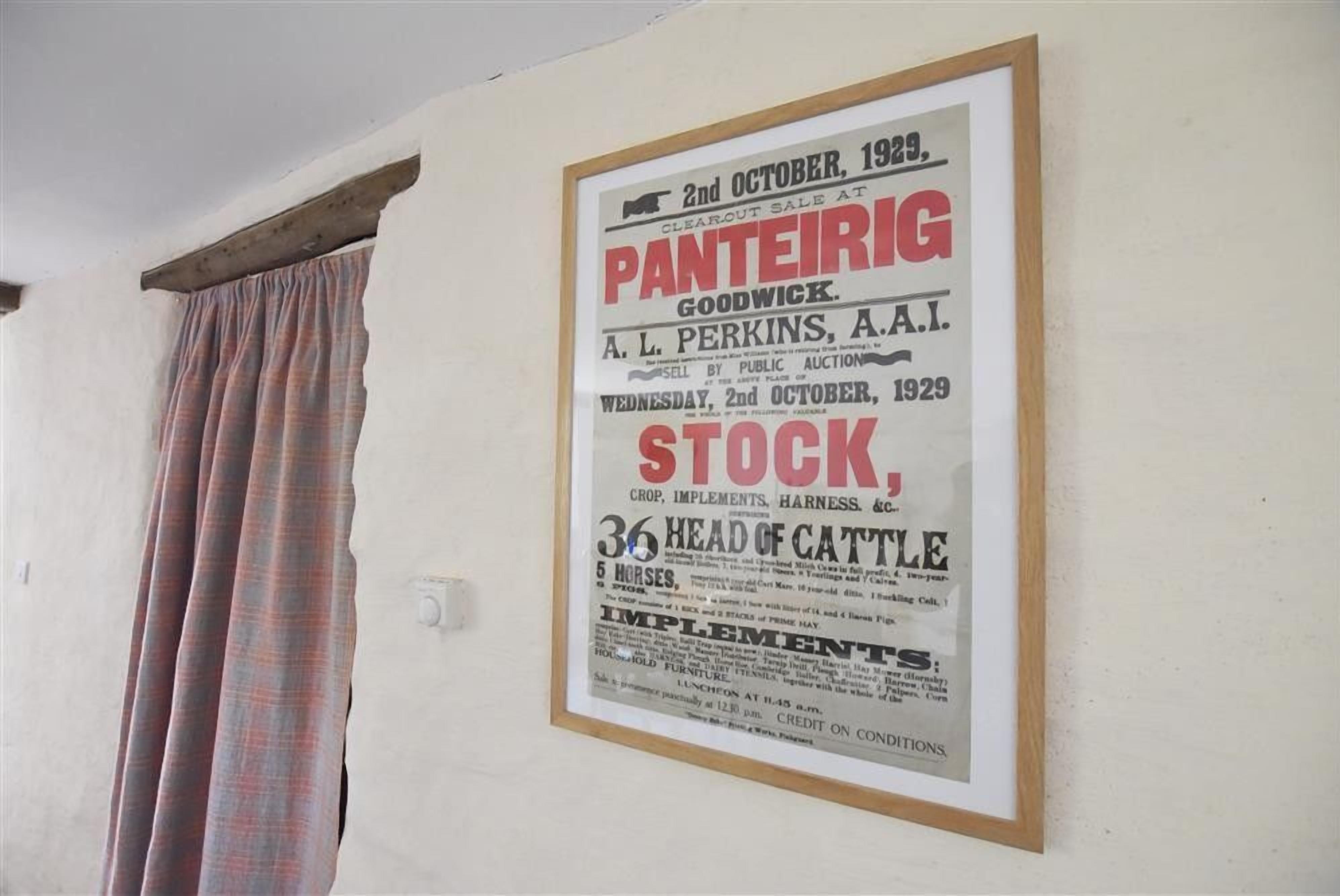 Een lijst met een advertentie voor een veiling van een runderhoofd aan een muur.