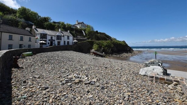 A pebble beach with buildings on a hillside, overlooking the sea. - 5 The Coach House (Haverfordwest)