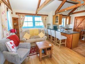 Relax in this inviting living space with a comfortable sofa, wooden coffee table, and bar counter.