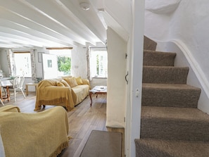 Une pièce comprenant un canapé, une table à manger et un escalier.