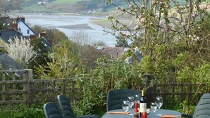 A table set outdoors with a view of a river and hills. - Gellifor (Cardigan)