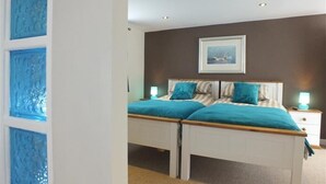 A bedroom with a double bed, two bedside tables, and a framed picture on the wall. - Pond Cottage (Llandysul)