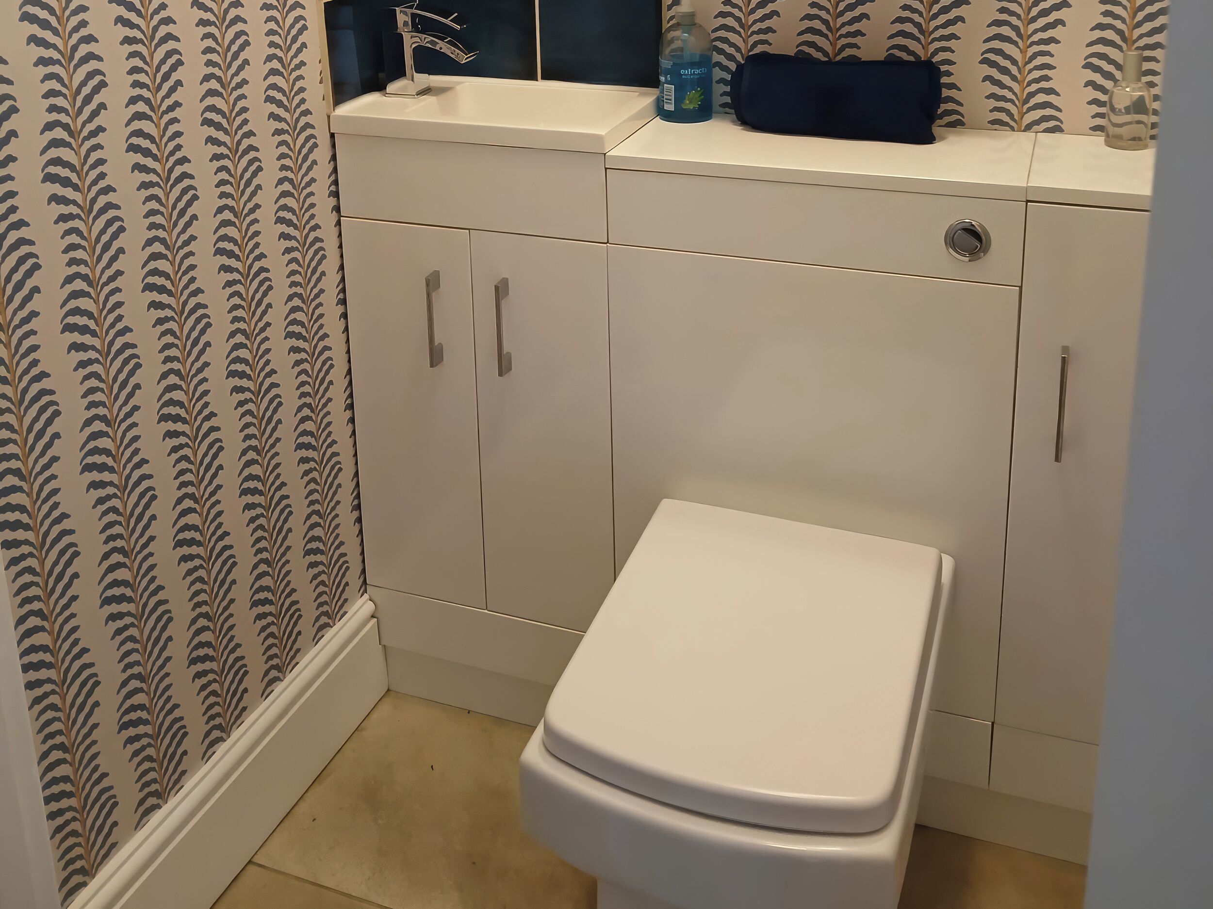 Une salle de bain avec des toilettes, un lavabo et un meuble de rangement.