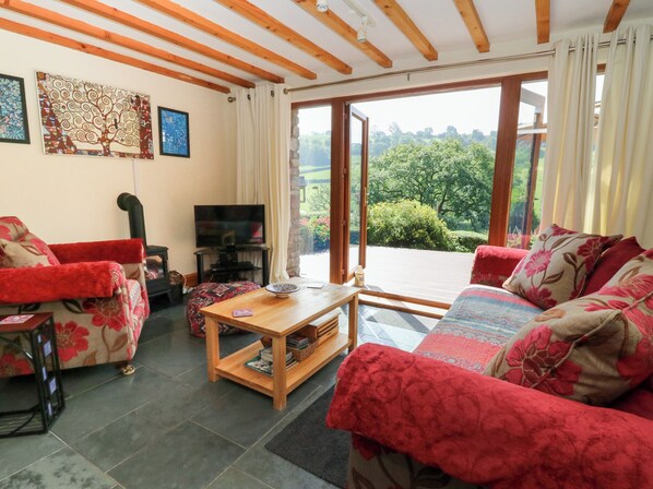 A furnished living room with a television, a coffee table, and a sofa set.