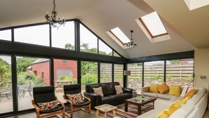 Un salón amplio con ventanas grandes, techo alto y vistas al exterior.