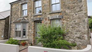 Un edificio de piedra con varias ventanas y una puerta verde.