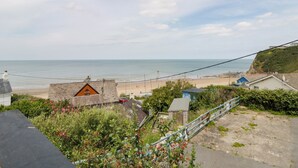 A coastal view with a beach, houses, and a clear sky.