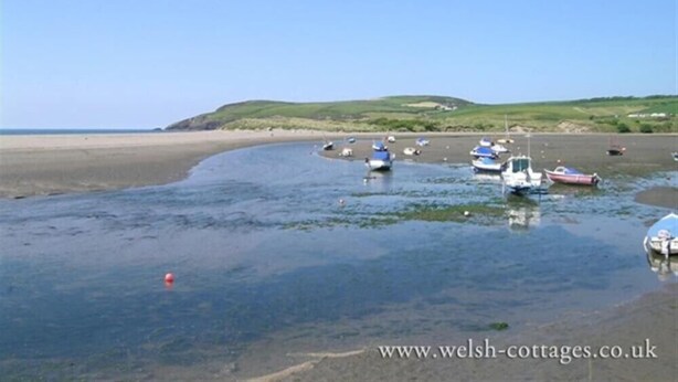 A coastal scene with boats on a sandy beach and calm water. - Gwelfor, Newport (Fishguard)
