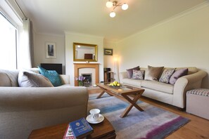 A living room with a sofa, a coffee table, and a fireplace. - Greenfields (Haverfordwest)