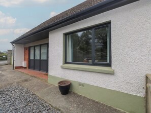 A building with a white exterior, a large window, and a door. - Greenfields (Haverfordwest)