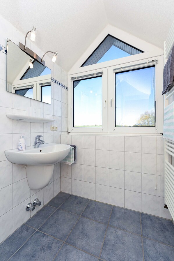 A modern bathroom with a white sink, a mirror, and a window above the sink. - Seeschwalbe Double Room at the Hotel-Pension Altes Siel - Double Room (Esens)