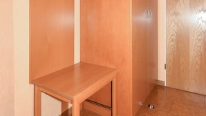 Una stanza con un armadio in legno, un tavolino e una porta.
