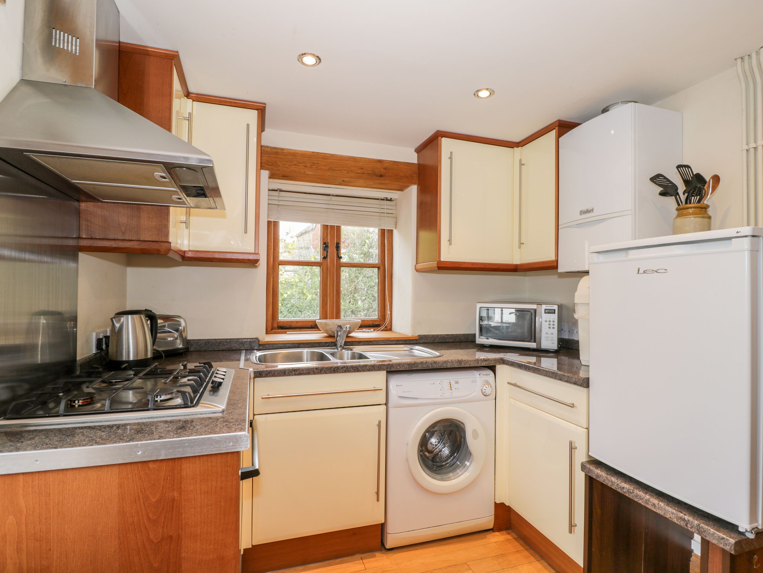 A compact kitchen with a gas stove, a microwave, a dishwasher, and a refrigerator.
