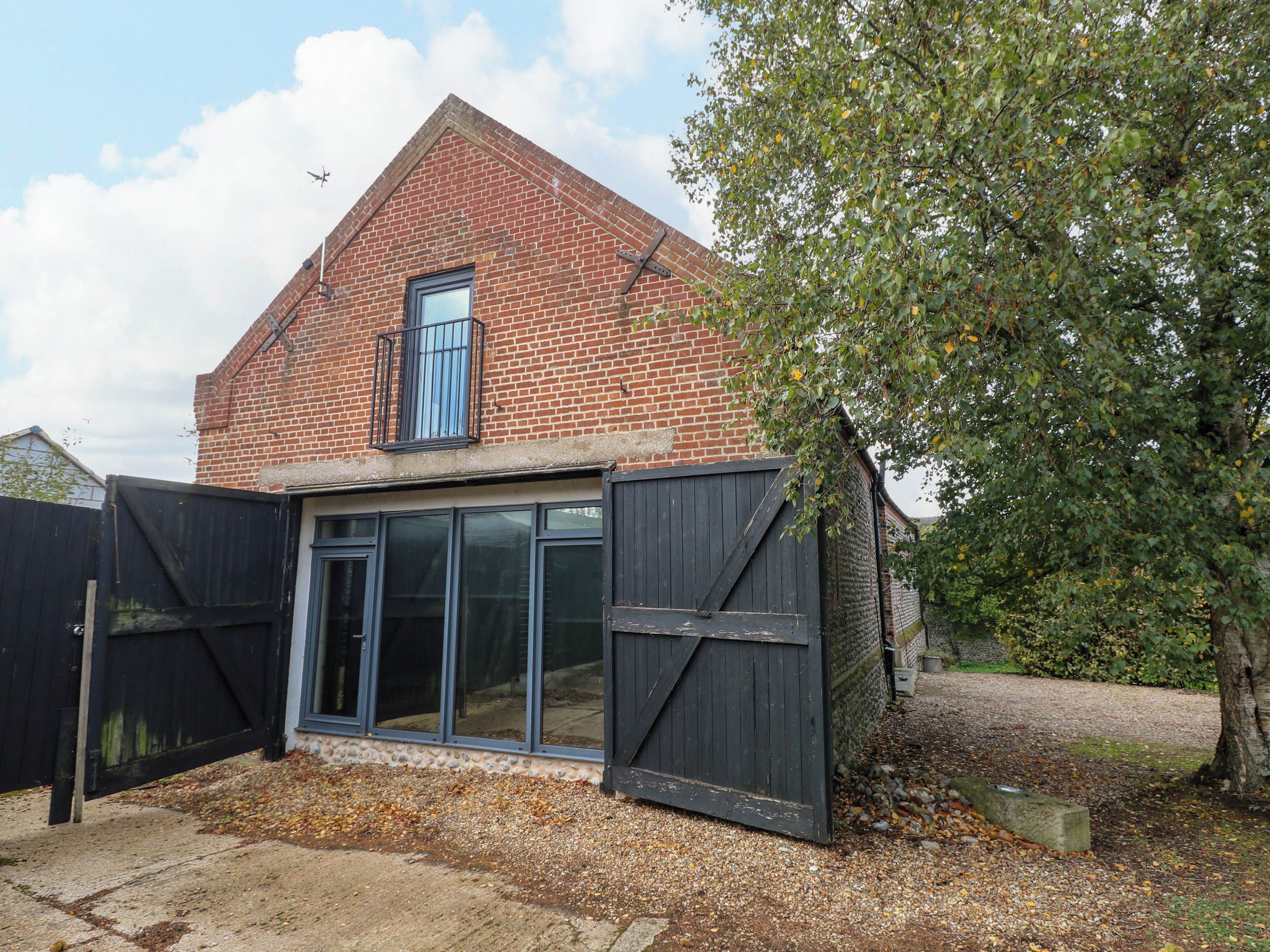 A brick house with a large window and a black gate.