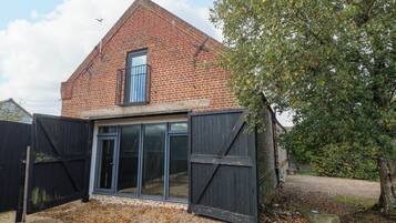 A brick house with a large window and a black gate.