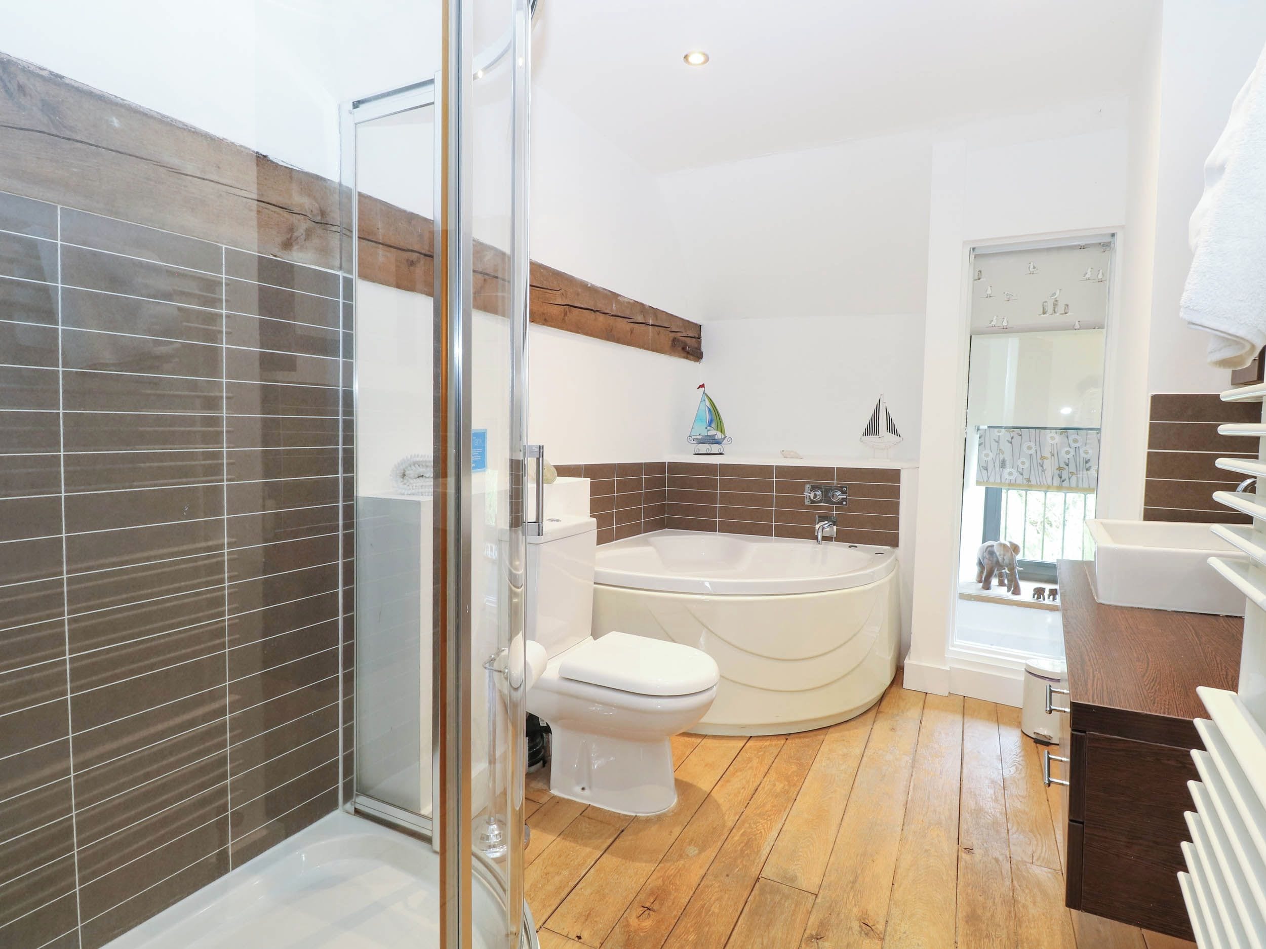 Et moderne badeværelse med en glasbrusekabine, et fristående badekar og et toilet.