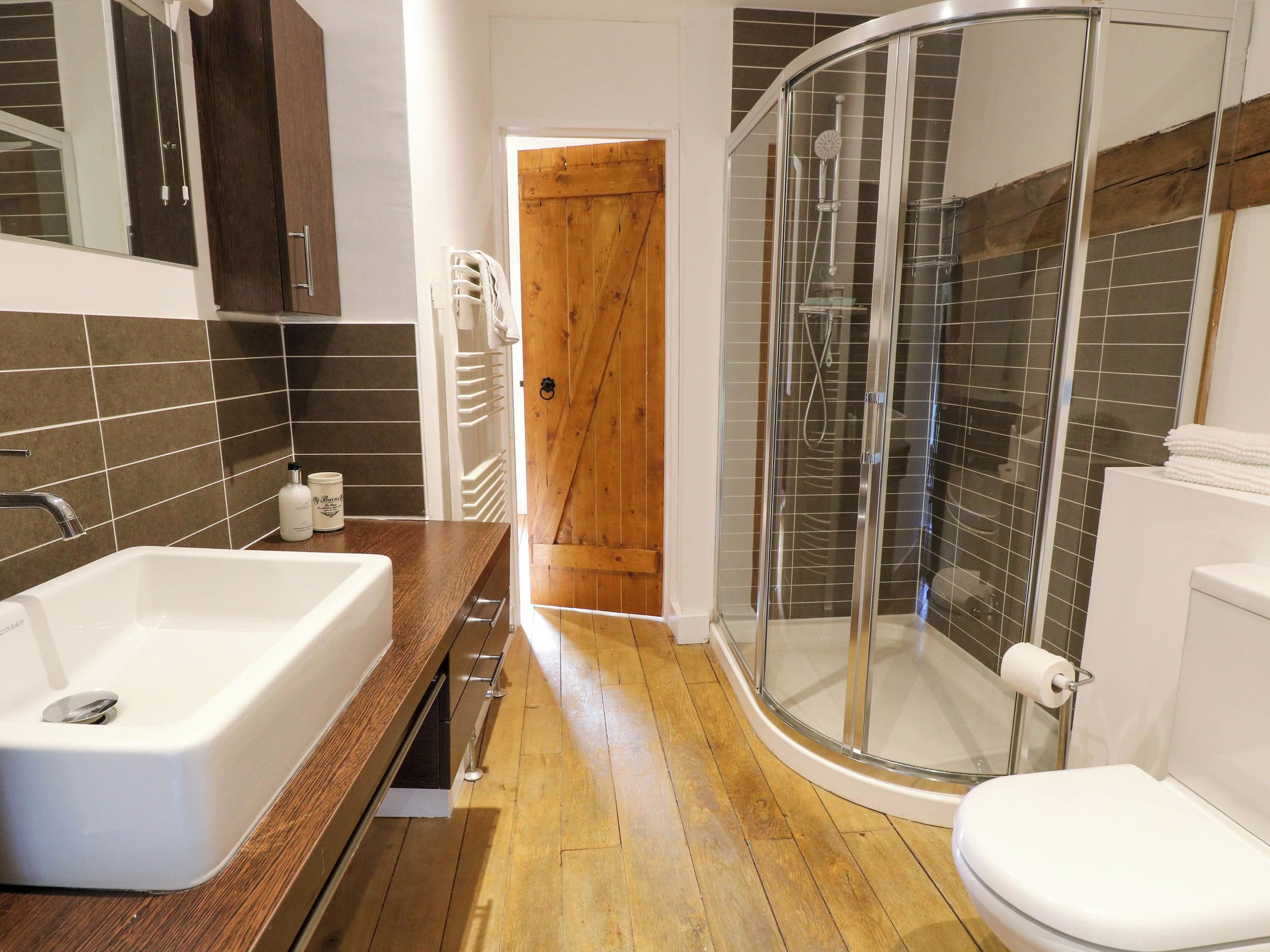 Un bagno con doccia, WC e lavandino.