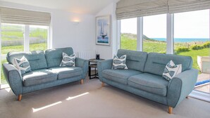 A room with two sofas, a small table, and a painting. - 7 Ocean's Edge (Kingsbridge)