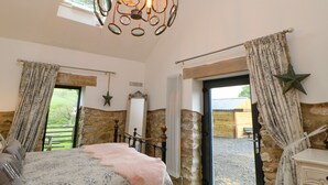 A bedroom with a bed, a star decoration, a mirror, and a view of the outside. - Briar Barn (Bishop Auckland)