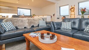 A modern living room with a leather sofa set, a wooden coffee table, and a fireplace. - Idlewild, 2 Wheal Turnavore (St. Agnes)