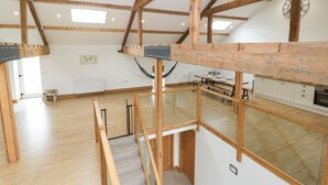 Un loft spacieux avec des poutres apparentes, un plafond haut et une grande fenêtre.