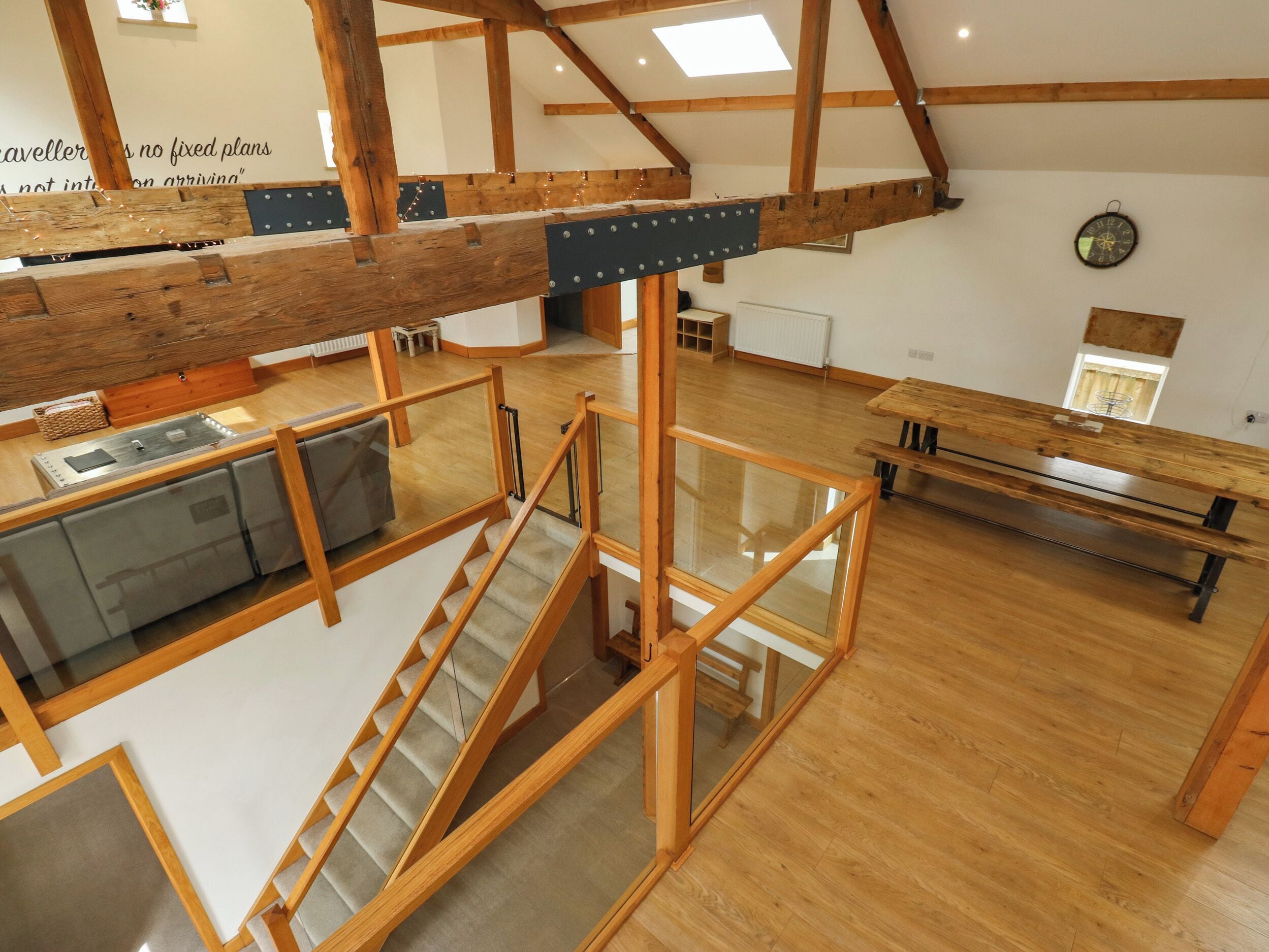 Un loft amplio con vigas de madera, una escalera y una zona de comedor.