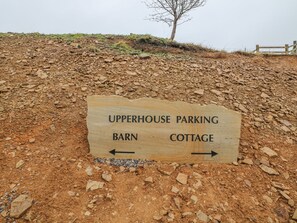 A sign indicating directions to Upperhouse Parking, Barn, and Cottage. - Upper House Barn (Oldham)