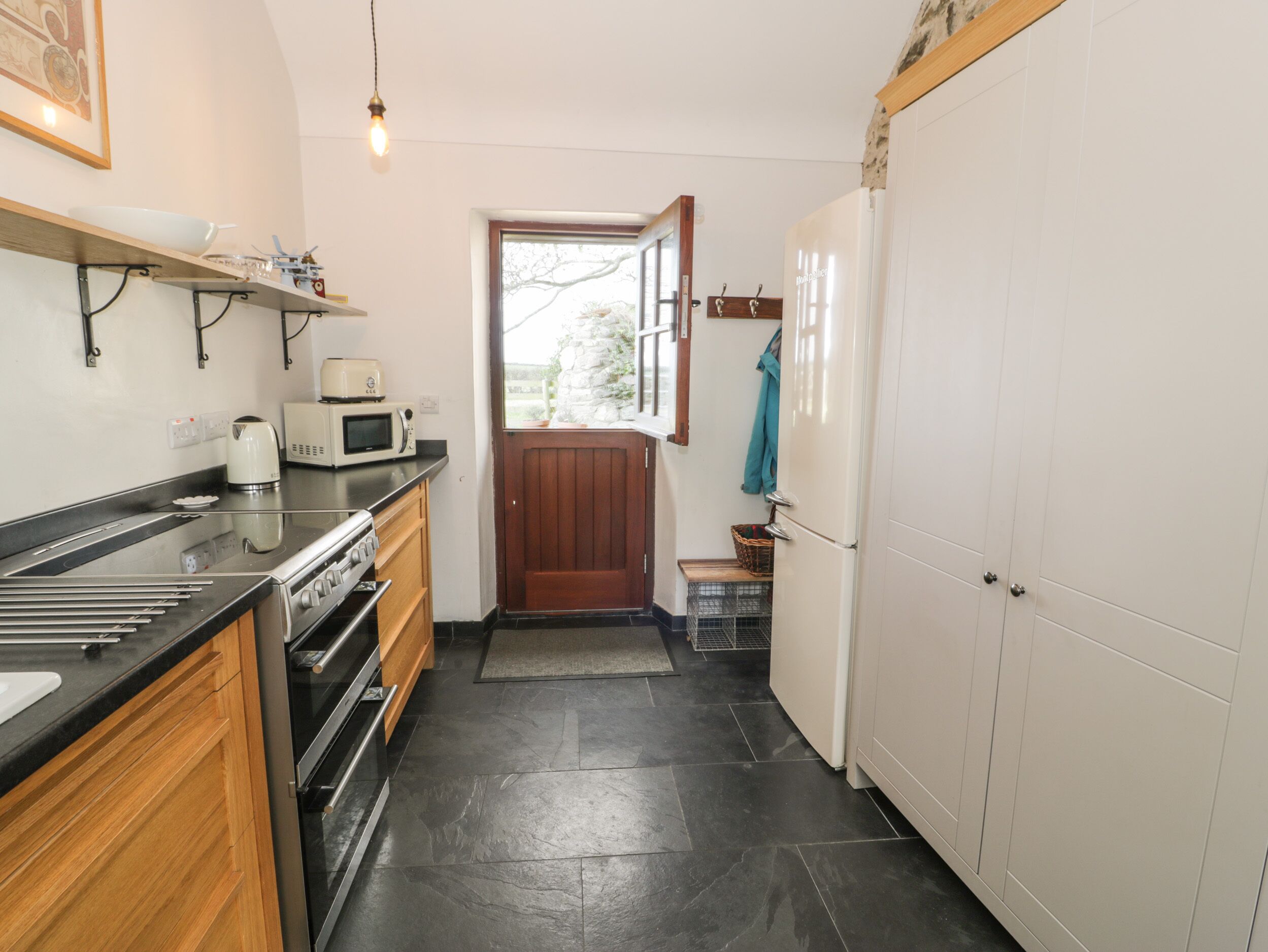 A compact kitchen with a stove, microwave, and a sink.