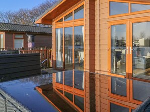 A modern building with large glass windows and a wooden exterior. - Shore Beats Work - Capenwray 10 (Carnforth)