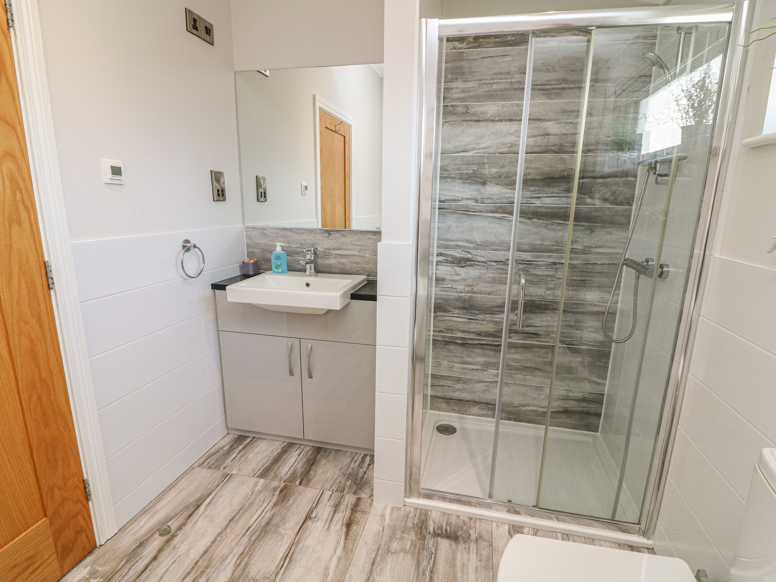 Une salle de bain avec une douche, un lavabo et des toilettes.