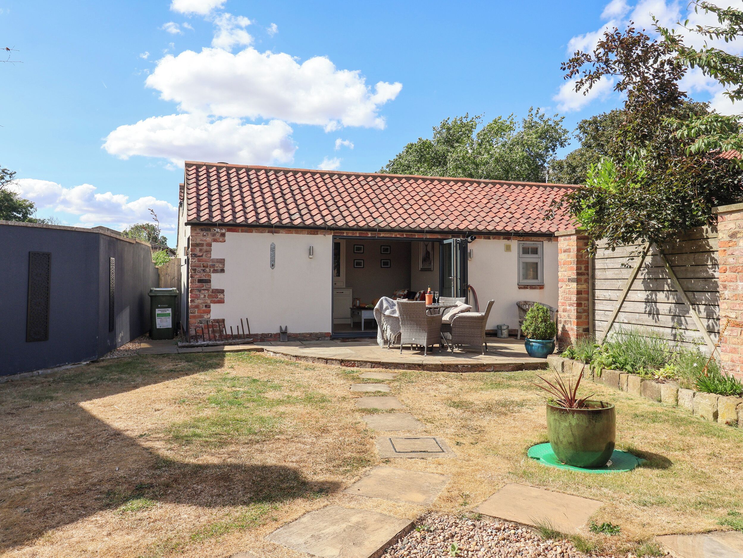 A residential property with a patio, outdoor seating, and a garden area.