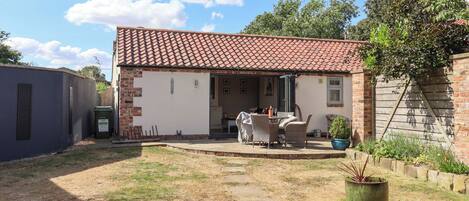 A residential property with a patio, outdoor seating, and a garden area.